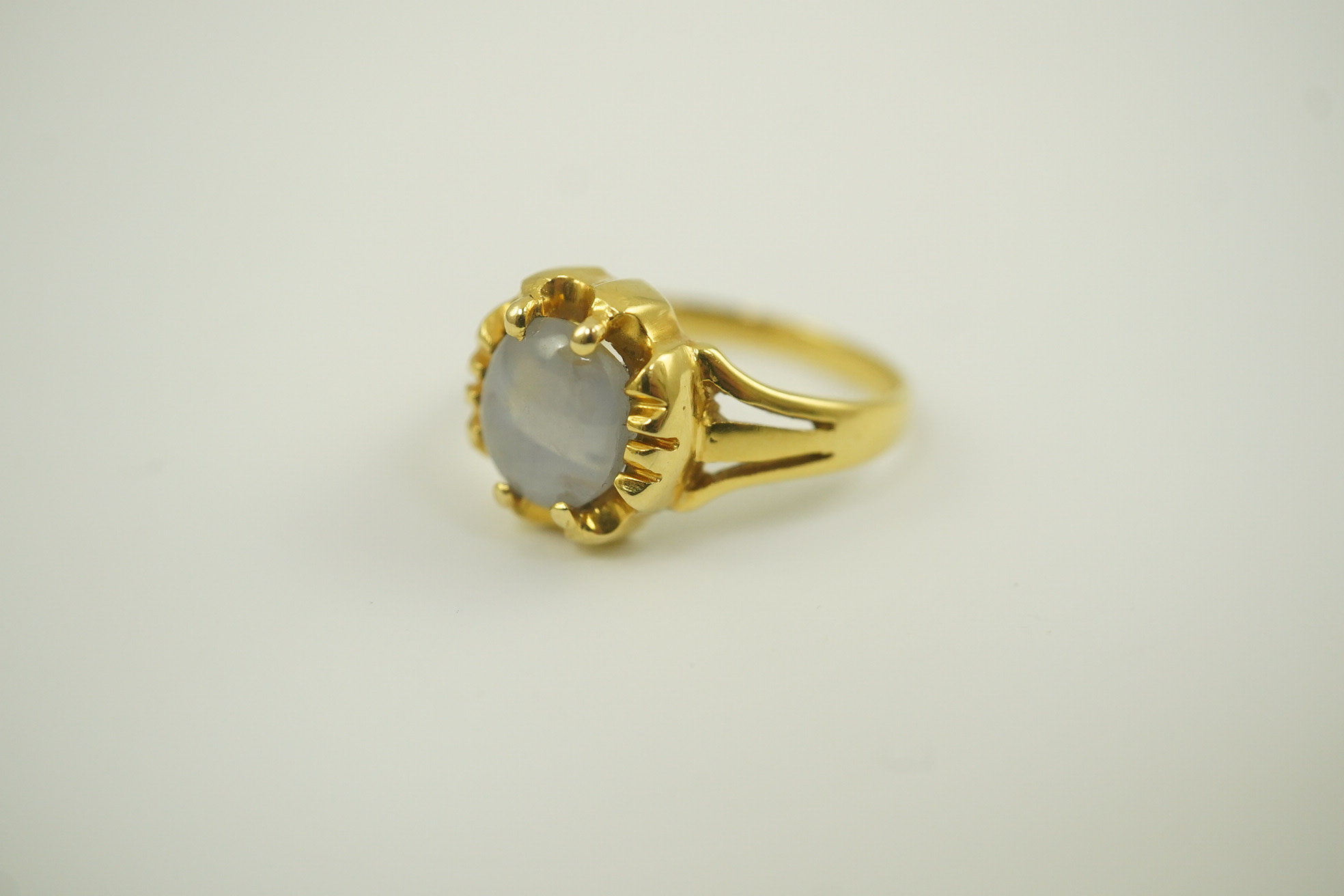 A modern 18k gold and single stone cabochon star sapphire set ring